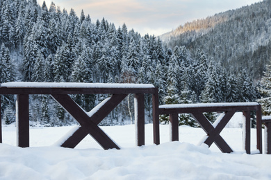 Photo of Wooden fence covered with snow outdoors on winter day