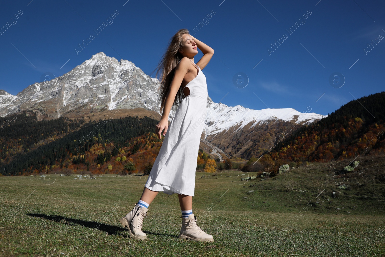 Photo of Young woman walking in beautiful mountains on sunny day