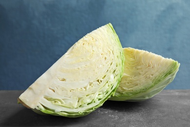 Photo of Pieces of cabbage on dark table. Healthy food