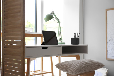 Photo of Stylish room interior with comfortable workplace near window