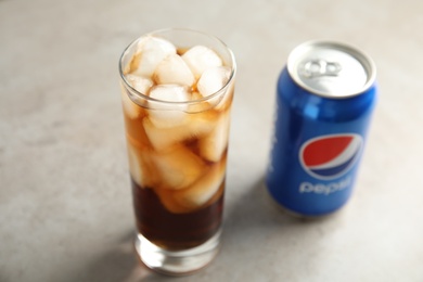 MYKOLAIV, UKRAINE - FEBRUARY 10, 2021: Glass and can of Pepsi on grey table