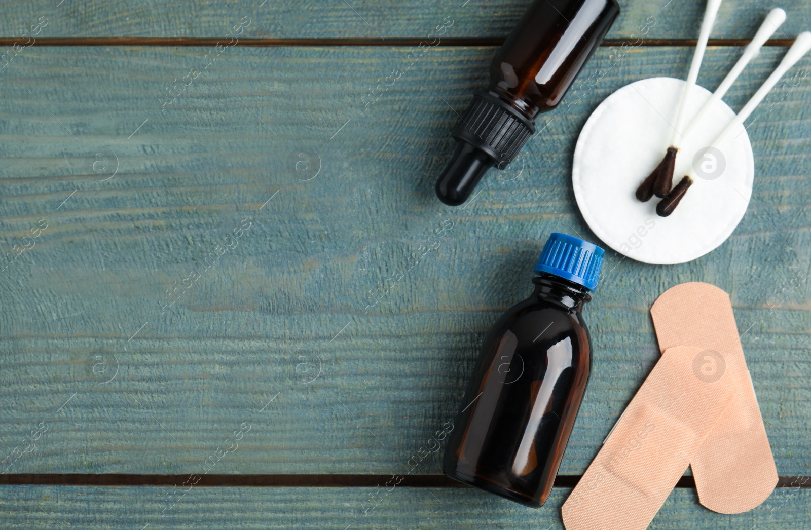 Photo of Flat lay composition with bottles of medical iodine on light blue wooden table. Space for text