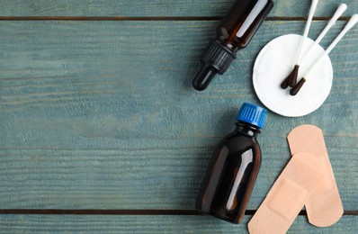 Photo of Flat lay composition with bottles of medical iodine on light blue wooden table. Space for text