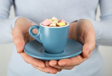 Woman holding cup of delicious hot chocolate with marshmallows, closeup