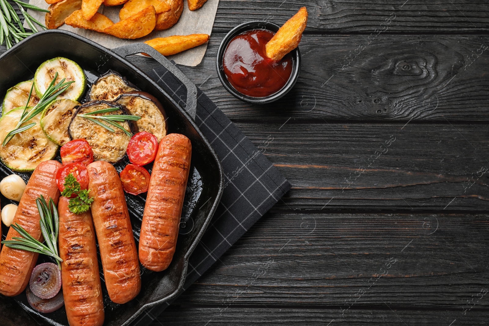 Photo of Flat lay composition with delicious grilled sausages on dark wooden table, space for text. Barbecue food