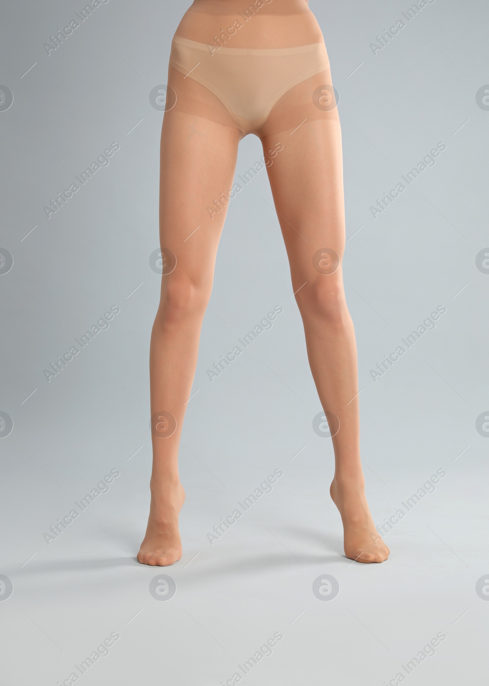 Photo of Woman wearing tights on light grey background, closeup of legs