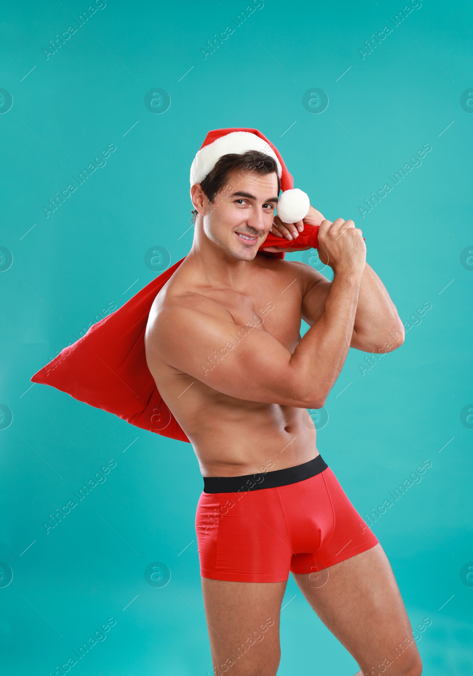 Photo of Sexy shirtless Santa Claus on blue background