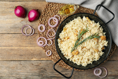 Photo of Delicious chicken risotto served on wooden table, flat lay