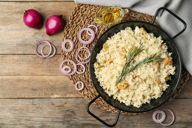 Delicious chicken risotto served on wooden table, flat lay