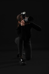 Photo of Professional photographer taking picture on black background