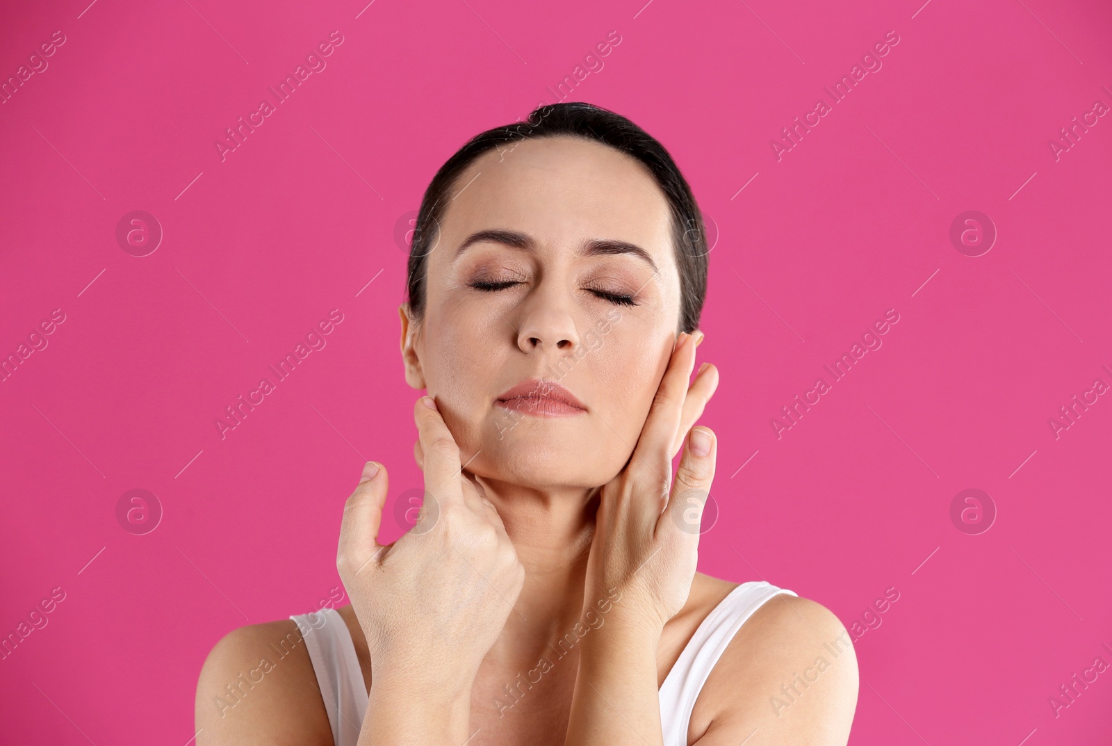 Photo of Portrait of beautiful mature woman on pink background