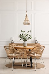 Dining room interior with comfortable furniture and eucalyptus branches