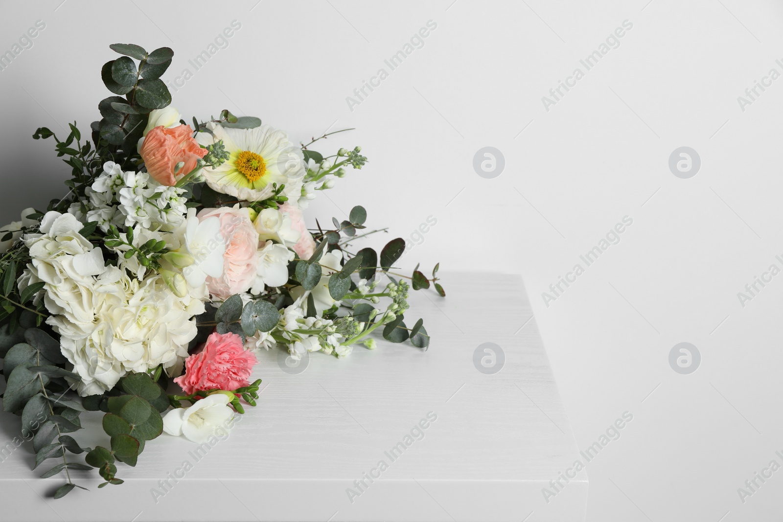 Photo of Bouquet of beautiful flowers on white wooden table. Space for text