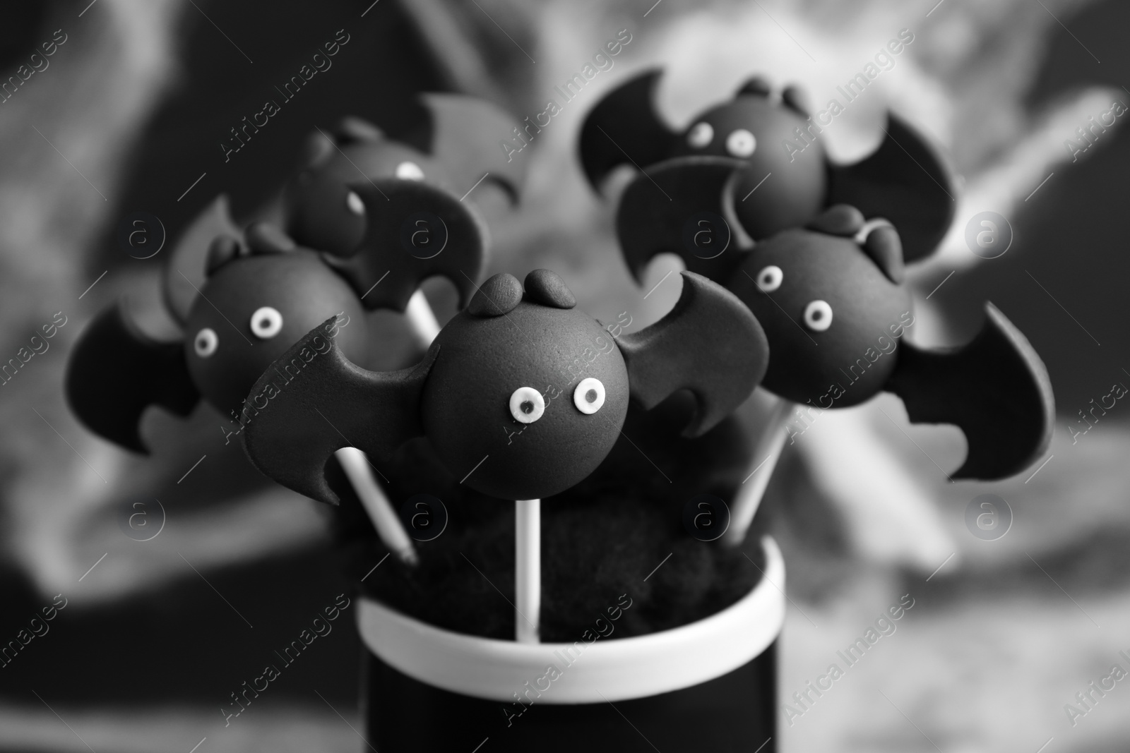 Photo of Bat shaped cake pops on dark background, closeup. Halloween treat
