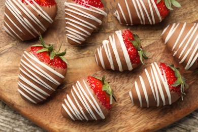 Delicious chocolate covered strawberries on wooden table, top view