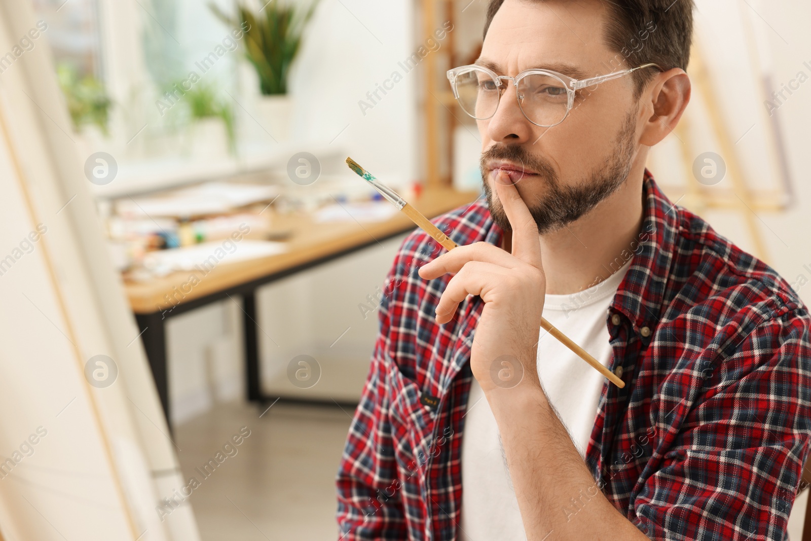 Photo of Man painting on canvas in studio. Creative hobby