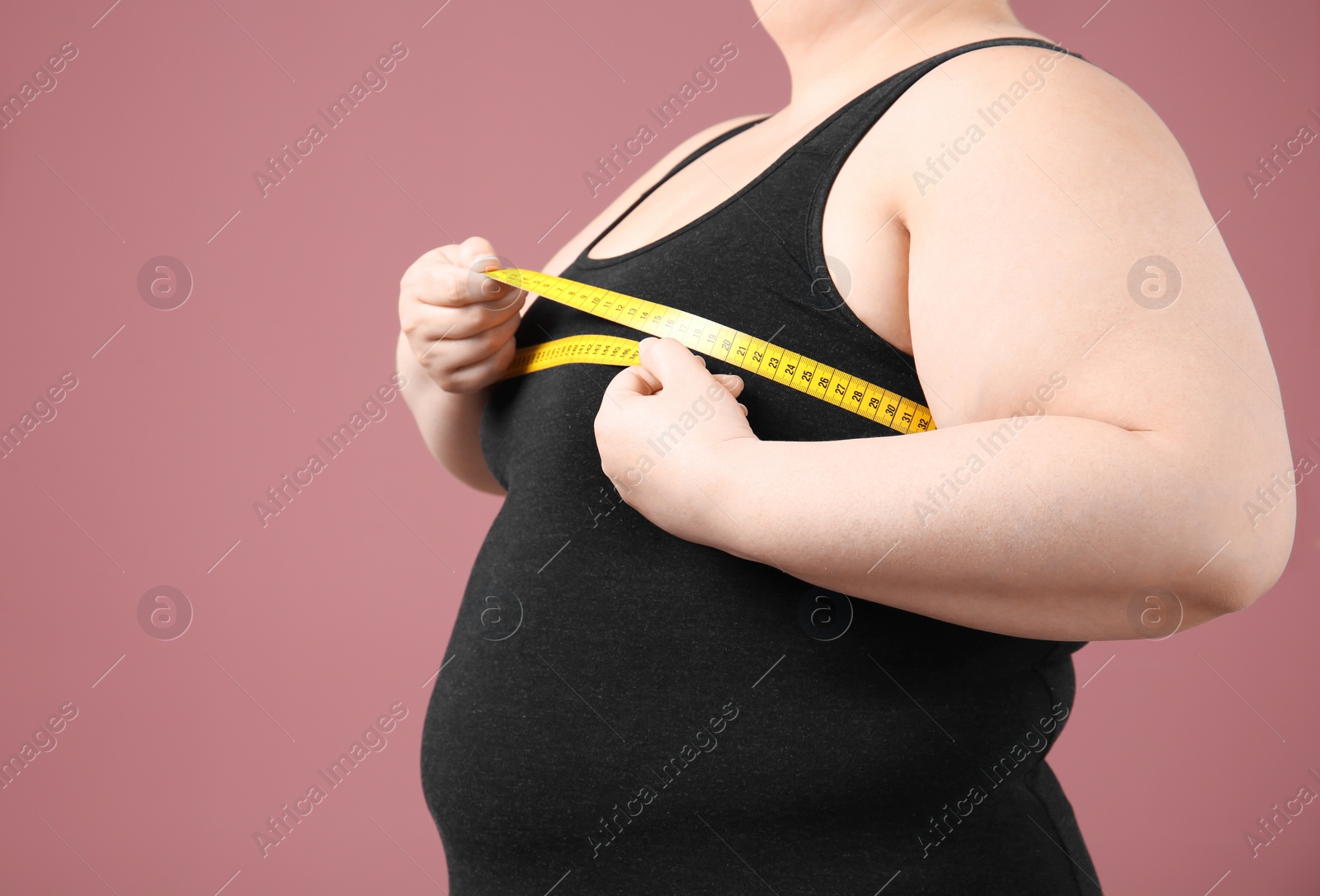 Photo of Overweight woman with measuring tape on color background