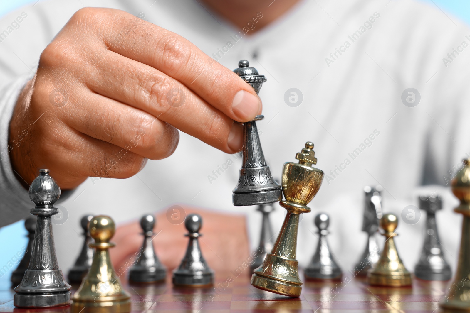 Photo of Man moving bishop chess piece at checkerboard, closeup