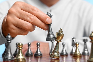 Man moving bishop chess piece at checkerboard, closeup