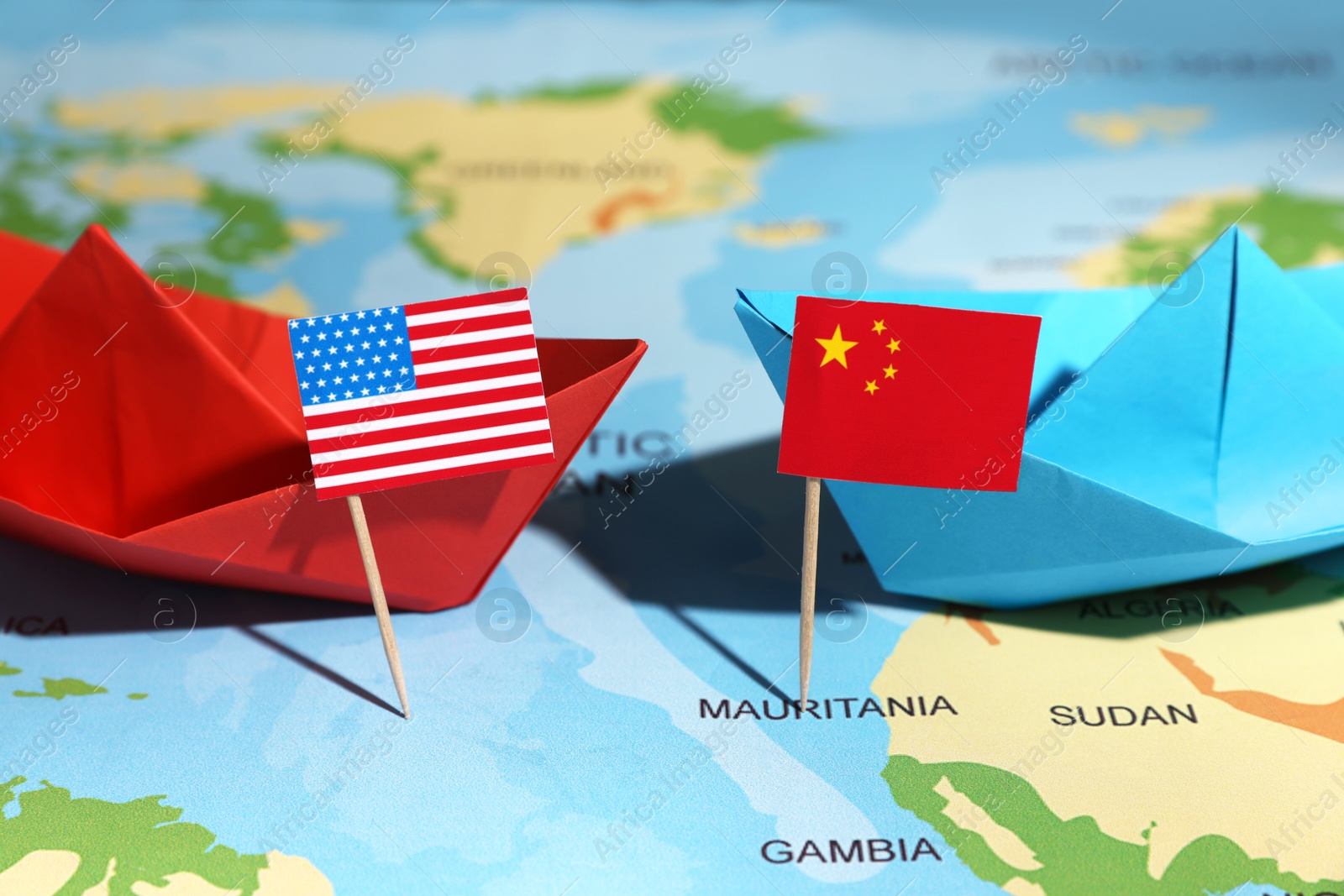 Photo of Paper boats with USA and China flags on world map, closeup. Trade war concept
