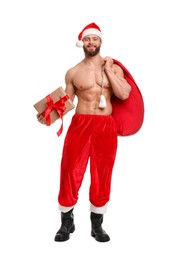 Attractive young man with muscular body in Santa hat holding bag and Christmas gift box on white background