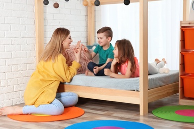 Photo of Nanny and little children playing at home