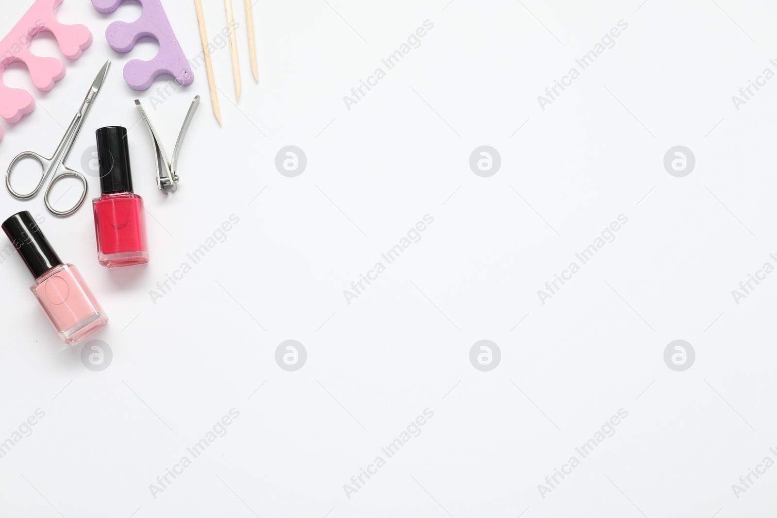 Photo of Nail polishes and set of pedicure tools on white background, flat lay. Space for text