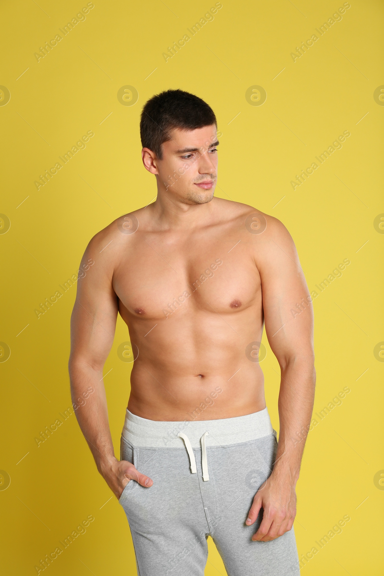 Photo of Man with sexy body on yellow background