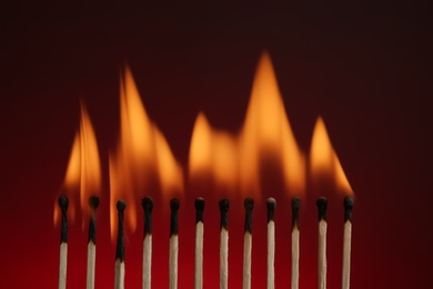 Photo of Line of burning matches on color background