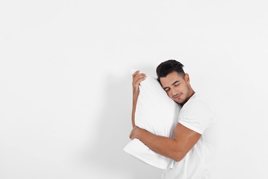 Photo of Young man with soft pillow on white background