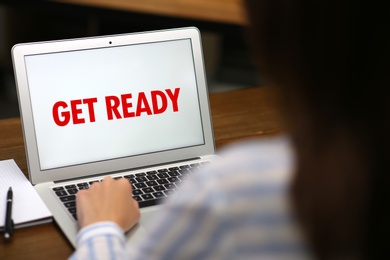 Image of Woman using laptop with phrase Get Ready at table, closeup