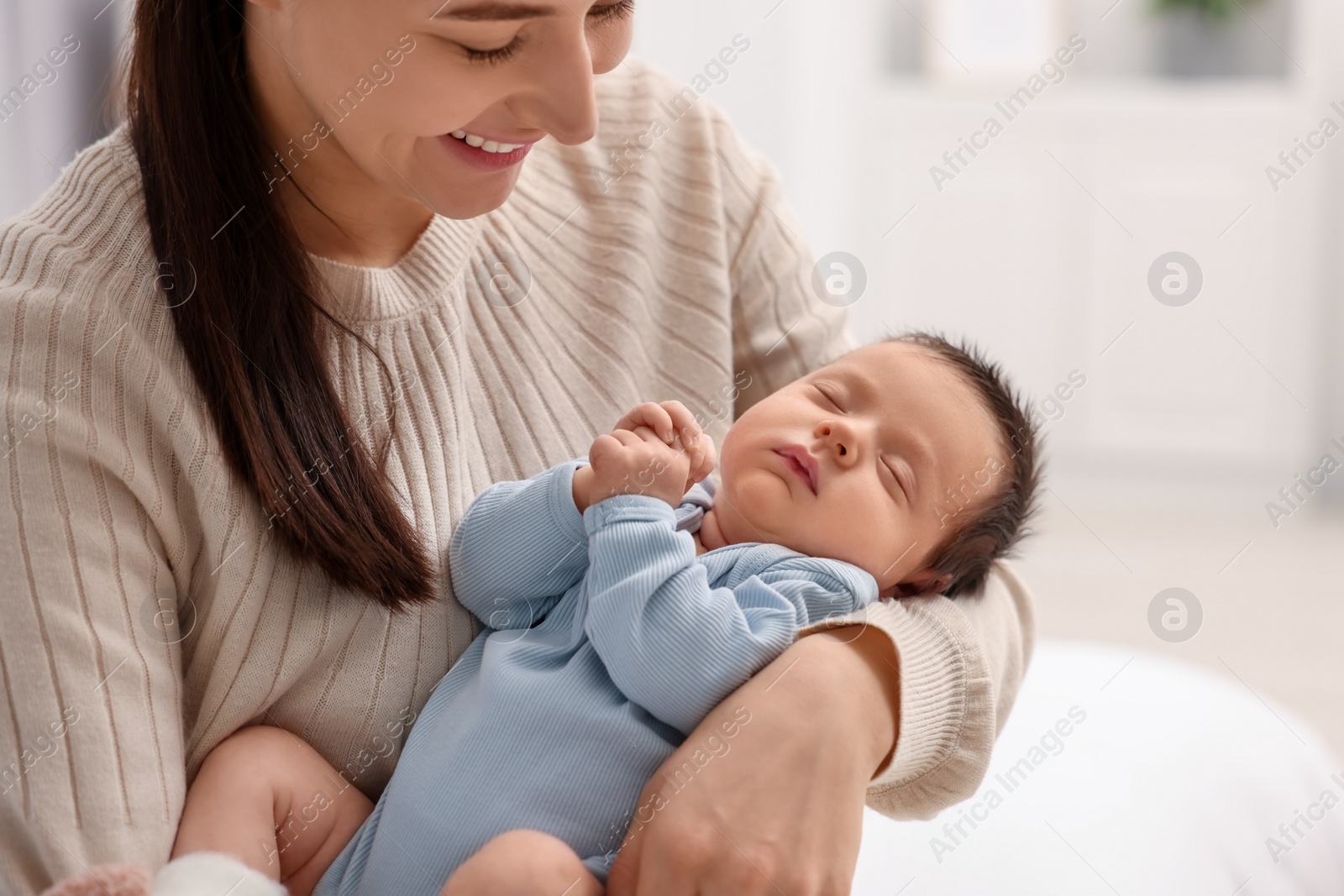 Photo of Mother with her sleeping newborn baby at home, closeup