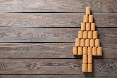 Photo of Christmas tree made of wine corks on wooden table, top view. Space for text