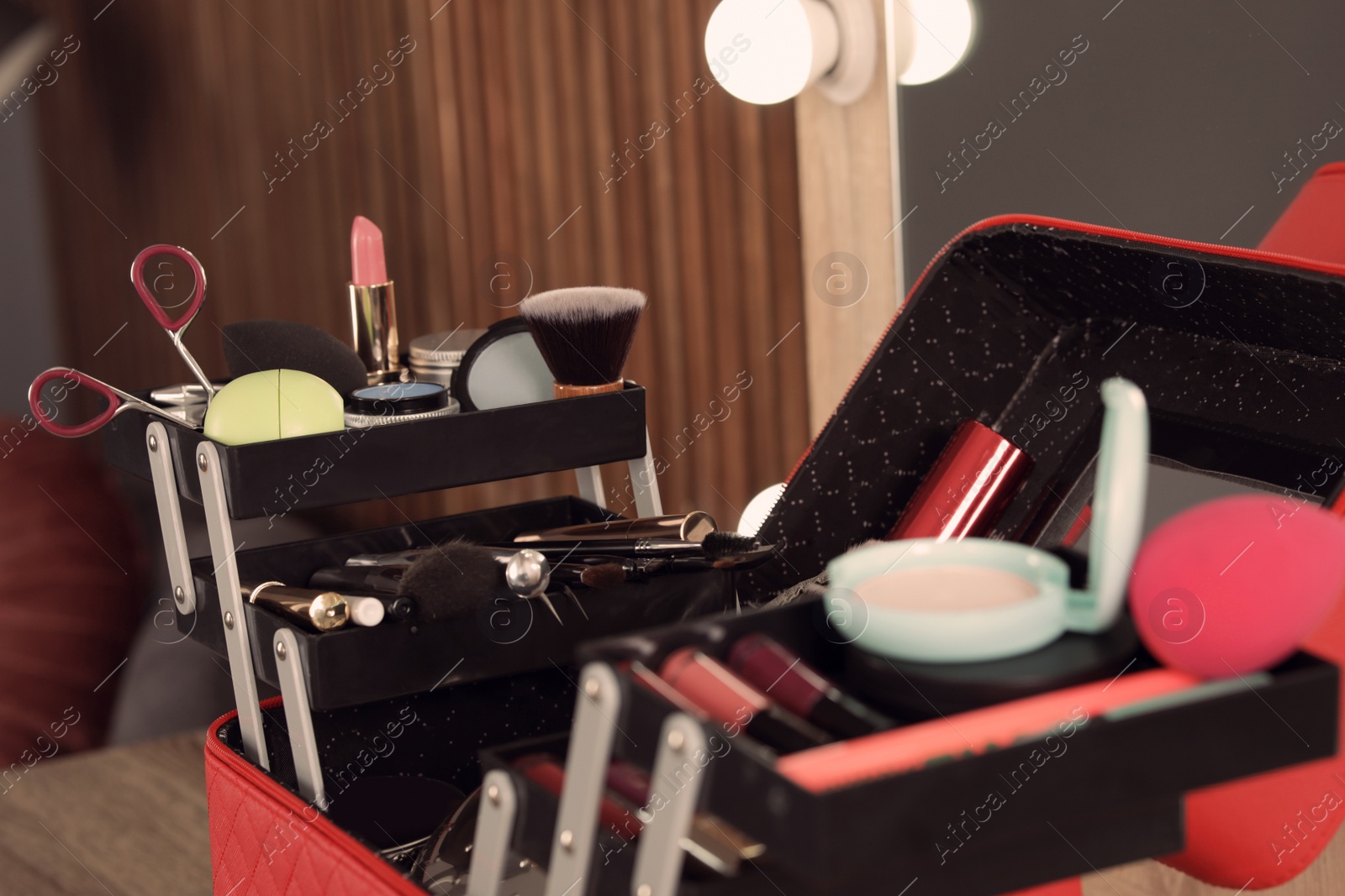 Photo of Beautician case with professional makeup products and tools on dressing table