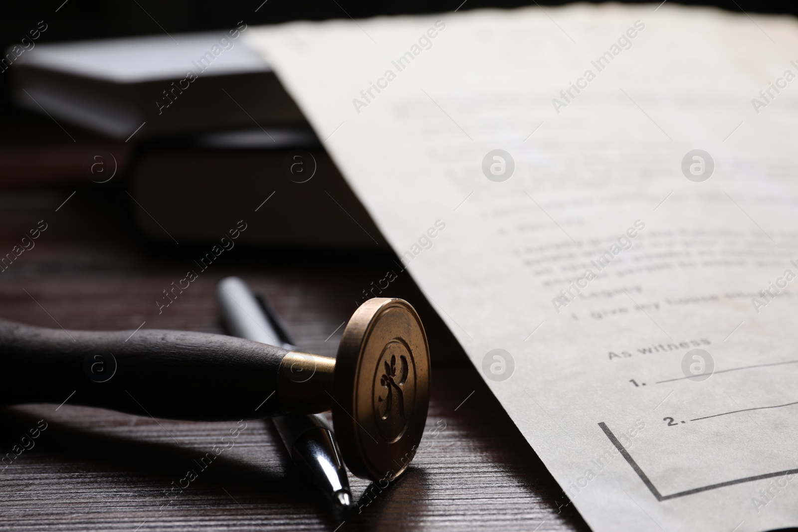 Photo of Last Will and Testament, stamp seal and pen on wooden table, closeup
