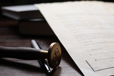 Last Will and Testament, stamp seal and pen on wooden table, closeup