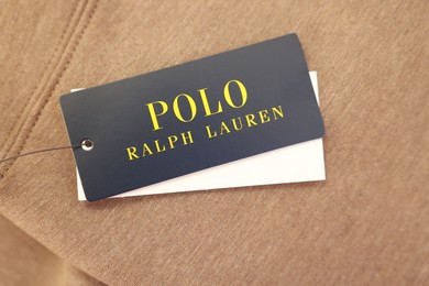 Photo of Leiden, Netherlands - December 6, 2023: Polo Ralph Lauren clothing tags on brown garment, top view