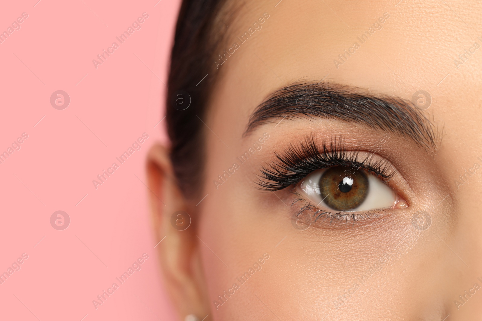 Photo of Beautiful young woman with long eyelashes on pink background, closeup