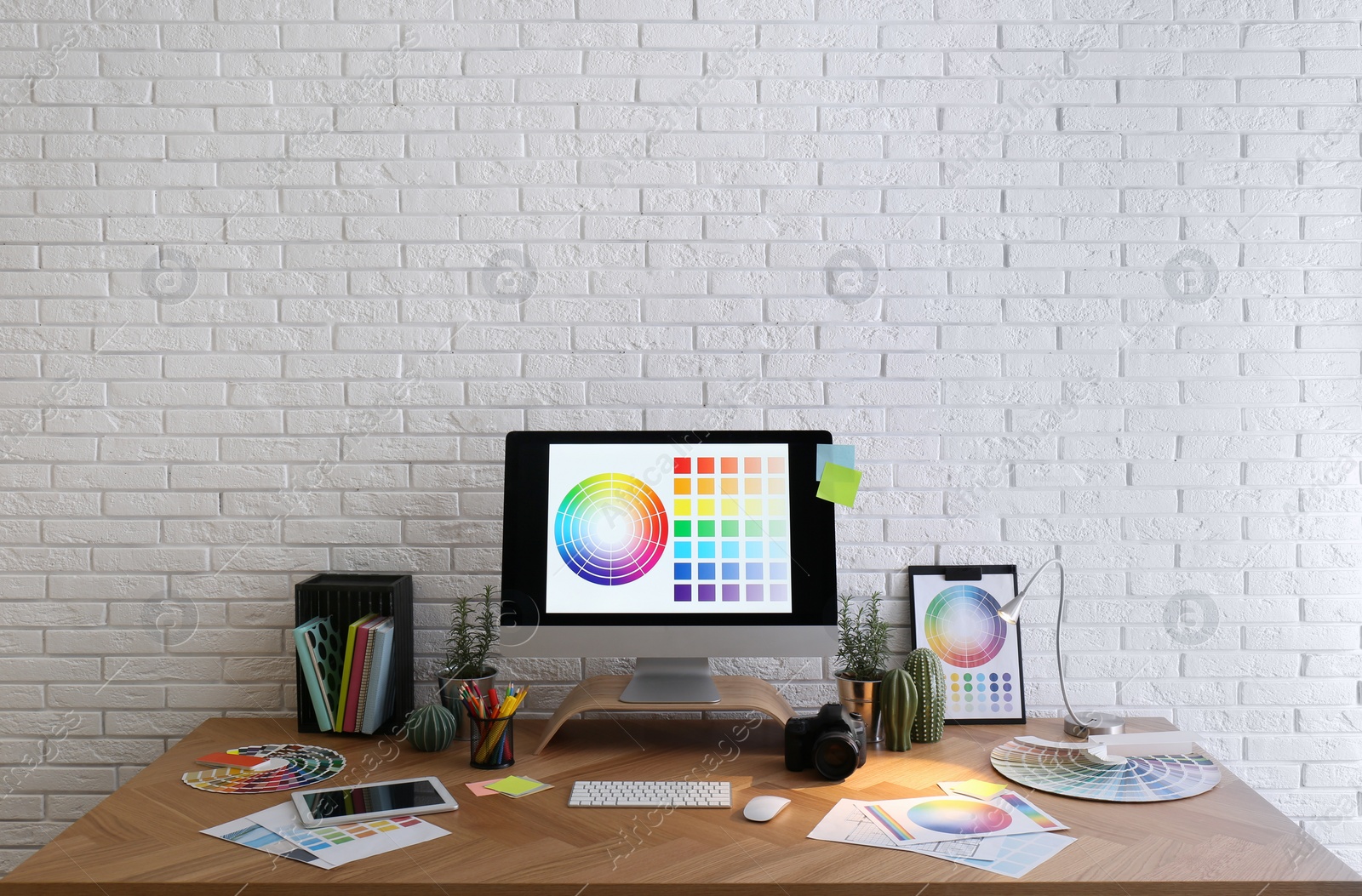 Photo of Modern computer and office supplies on wooden table. Designer's workplace