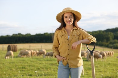 Photo of Portrait of smiling woman with shovel on pasture at farm. Space for text