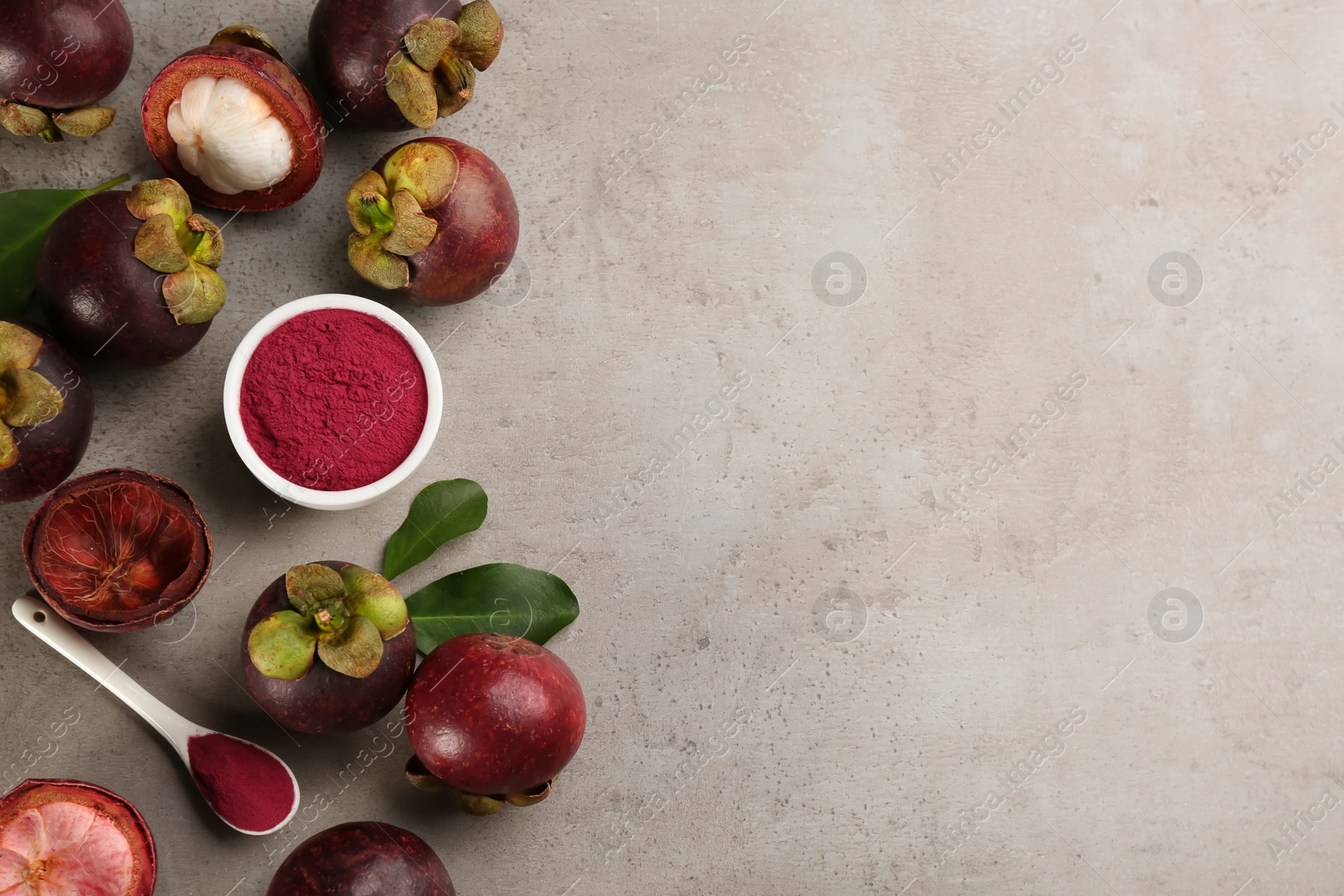Photo of Purple mangosteen powder and fruits on light grey table, flat lay. Space for text