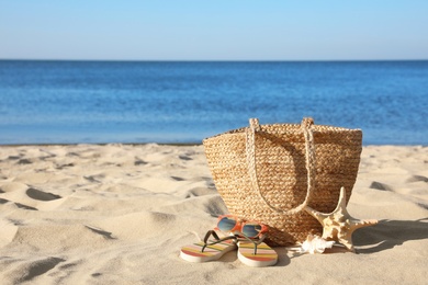 Photo of Set with stylish beach accessories on sand near sea