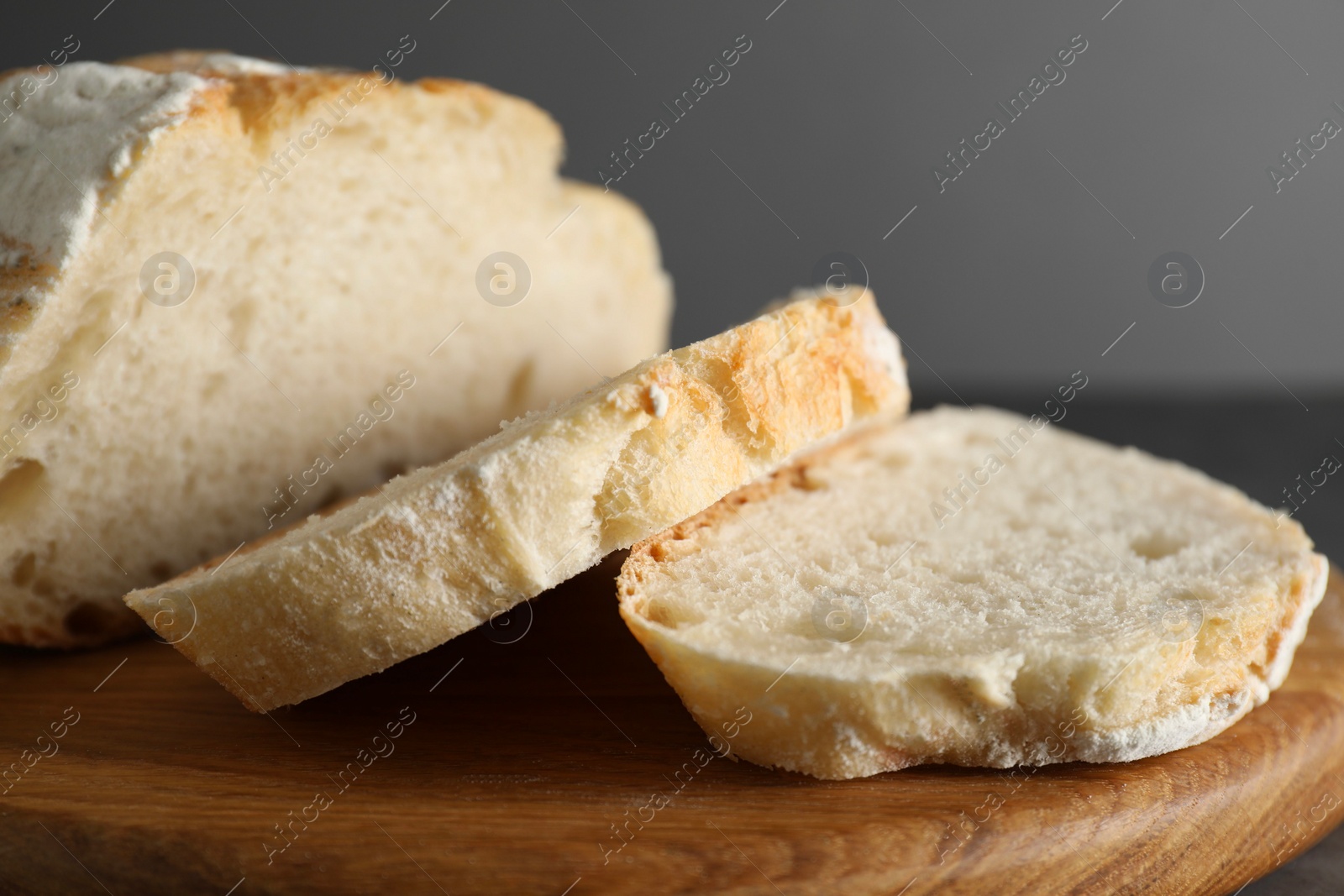 Photo of Freshly baked cut sourdough bread on grey table, closeup