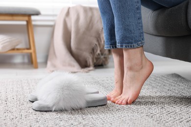 Woman near fluffy slippers at home, closeup