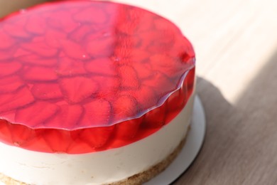 Delicious cheesecake with jelly and strawberries on wooden table, closeup