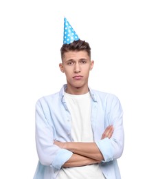 Photo of Sad young man in party hat with crossed arms on white background