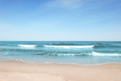 Photo of Blurred view of beautiful sea and sandy beach on sunny day