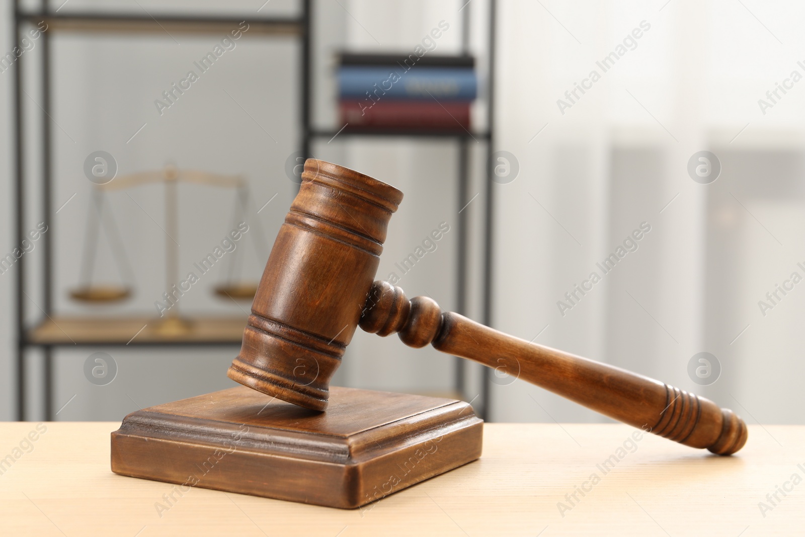 Photo of Wooden gavel and sound block on table indoors, closeup