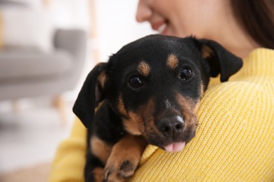 Photo of Woman with cute puppy indoors, closeup. Lovely pet