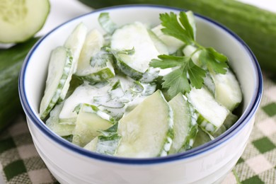 Photo of Delicious cucumber salad in bowl on table, closeup